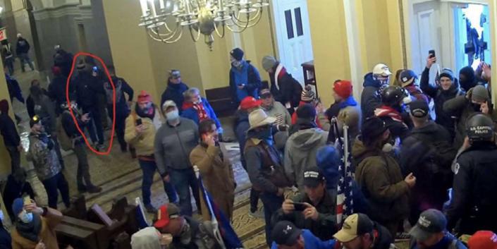 A security footage still from the FBI filing showing a group people inside the Capitol. The man who the FBI believe is Gary Edwards is circled.