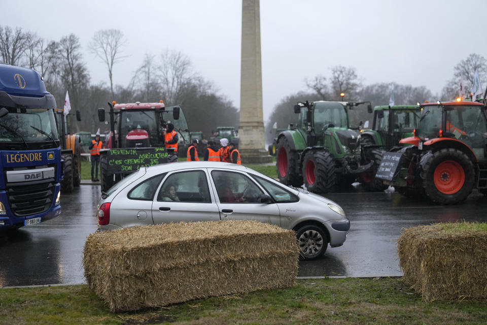 Farmers regulate traffic at a roundabout in Fontainebleau, south of Paris, Friday, Jan. 26, 2024 in Paris. Snowballing protests by French farmers crept closer to Paris with tractors driving in convoys and blocking roads in many regions of the country to ratchet up pressure for government measures to protect the influential agricultural sector from foreign competition, red tape, rising costs and poverty-levels of pay for the worst-off producers. (AP Photo/Thibault Camus)