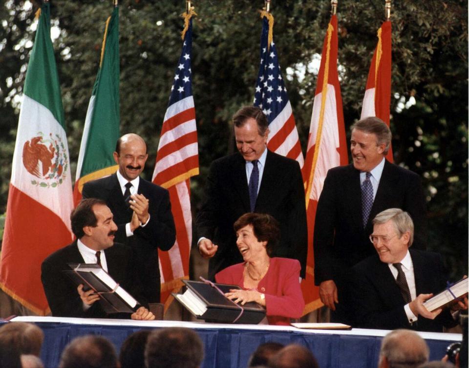 U.S. Trade Representative Carla Hills, seated in the centre, with her Mexican and Canadian counterparts, as well as all three countries' leaders, as they sign the North American Free Trade Agreement in 1992.
