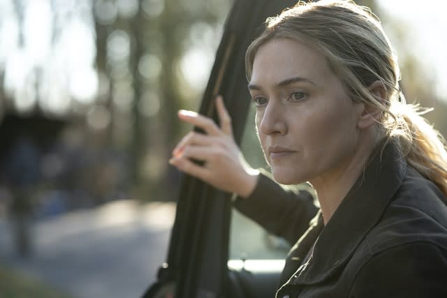 A woman getting out of her car in the woods