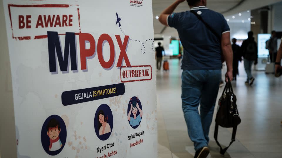 A passenger walks past a banner informing travelers about Monkeypox (MPOX) at Soekarno-Hatta International Airport in Tangerang, Indonesia on August 26, 2024. - Yasuyoshi Chiba/AFP/Getty Images