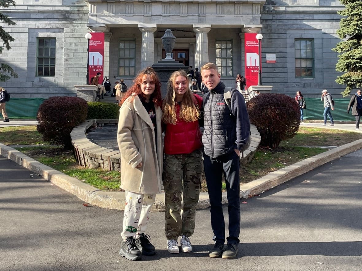 Genevieve Coben, Sophie Boehler and Harry North, all 20 years old, are pictured outside McGill University in Montreal. They're happy to be studying in Canada, they say, because they are able to combine degrees in unique ways. (Harry North - image credit)