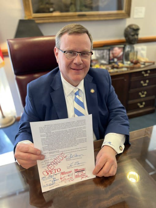 House Speaker Tim Moore holds a copy of a bill in which the Governor's veto was overridden by the General Assembly