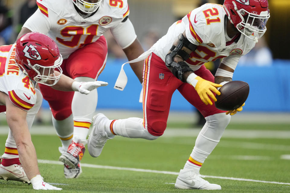 Kansas City Chiefs safety Mike Edwards (21) picks up a fumble before running it back for a touchdown during the first half of an NFL football game against the Los Angeles Chargers, Sunday, Jan. 7, 2024, in Inglewood, Calif. (AP Photo/Ashley Landis)