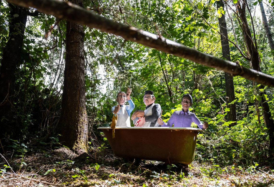 The Never Never Land statue, Three Men in a Tub, sits in the woods on a trail created by Rod Collen and Shannon Garrett at their mushroom house that they built from the ground up together on their property in Lakebay, Wash. August 13, 2022. Never Never Land, an amusement park that was based off of fairytales that closed in 2001, auctioned off the remaining statues which Rob and Shannon acquired three of.