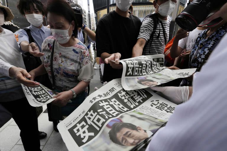 Las personas leen el periódico Yomiuri Shimbun que informa sobre el asesinato del exprimer ministro japonés Shinzo Abe, el viernes 8 de julio de 2022, en Tokio.