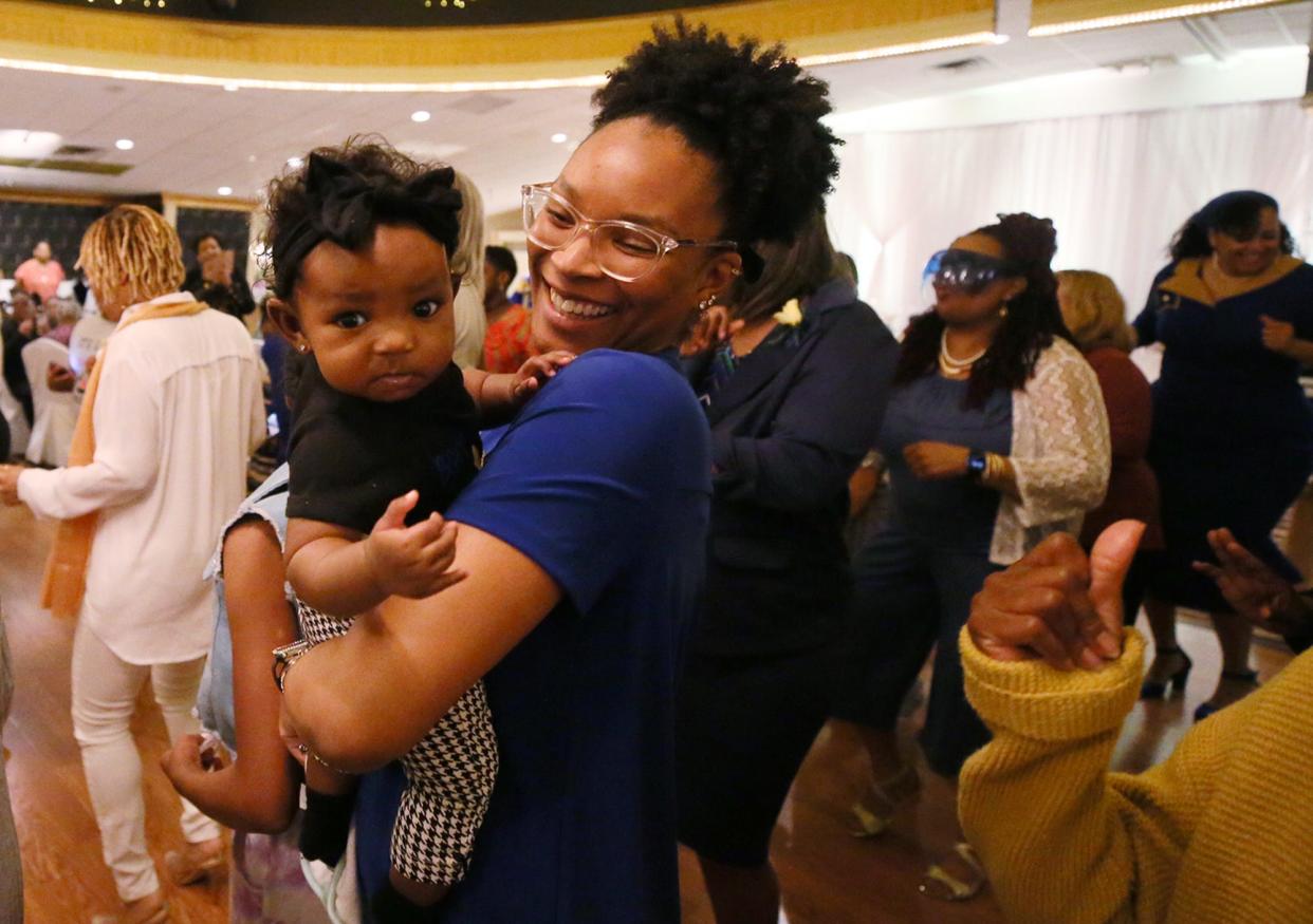 Monique Ransome dances with her 3-month-old daughter, Mozi, at the Sigma Gamma Rho Sorority Akron Alumni Chapter's mother-daughter luncheon Saturday.