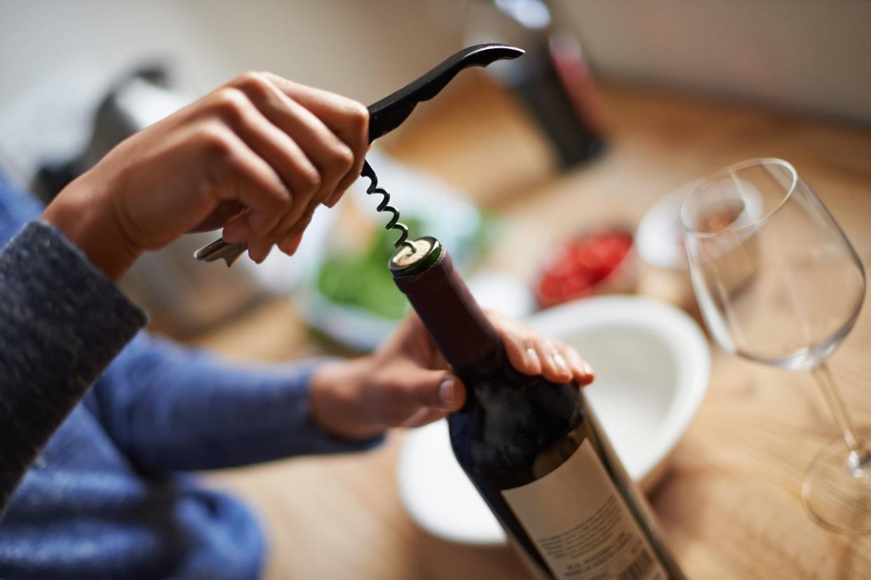 opening bottle of wine with corkscrew
