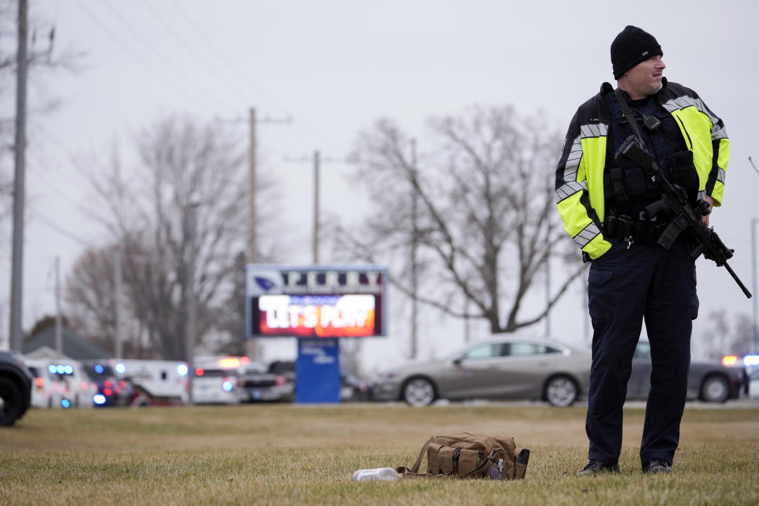 A police officer holding a semiautomatic rifle outside Perry High School in Perry, Iowa.