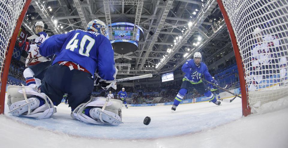 USA forward Phil Kessel, right, watches as his third goal sails past Slovenia goaltender Luka Gracnar during the third period of a men's ice hockey game at the 2014 Winter Olympics, Sunday, Feb. 16, 2014, in Sochi, Russia. (AP Photo/Matt Slocum, Pool)