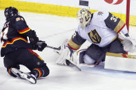 Vegas Golden Knights goalie Adin Hill makes a save against Calgary Flames' Kevin Rooney during the second period of an NHL hockey game Thursday, March 14, 2024, in Calgary, Alberta. (Larry MacDougal/The Canadian Press via AP)