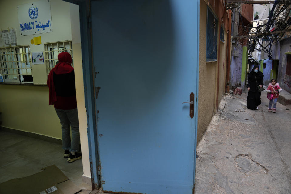 FILE - A Palestinian woman, left, receives medicine from a pharmacy run by the U.N. agency for Palestinian refugees, at the Bourj al-Barajneh Palestinian refugee camp, in Beirut, Lebanon, Tuesday, Jan. 18, 2022. United Nations Relief and Works Agency UNRWA Commissioner-General Philippe Lazzarini warned on Thursday, April 6, 2023, that it faced growing challenges in running its operations as donors were set to contribute less money this year.(AP Photo/Hussein Malla, File)