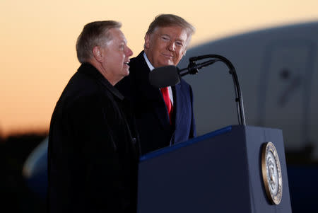 U.S. President Donald Trump listens to U.S. Senator Lindsey Graham (R-SC) speak during a campaign rally for Republican U.S. Senator Cindy Hyde-Smith in Tupelo, Mississippi, U.S. November 26, 2018. REUTERS/Kevin Lamarque/Files