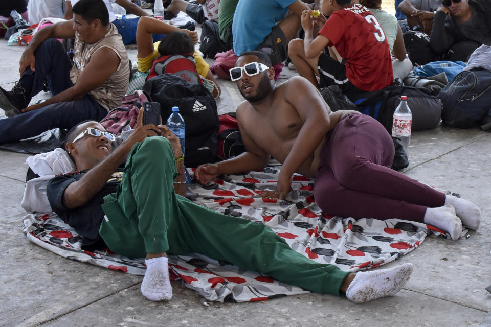 Migrants who are taking part in a caravan rest on the outskirts of Tapachula, Chiapas state, Mexico, Sunday, April 23, 2023. Migrants set out Sunday on what they call a mass protest procession through southern Mexico to demand the end of detention centers like the one that caught fire last month, killing 40 migrants. (AP Photo/Edgar H. Clemente)