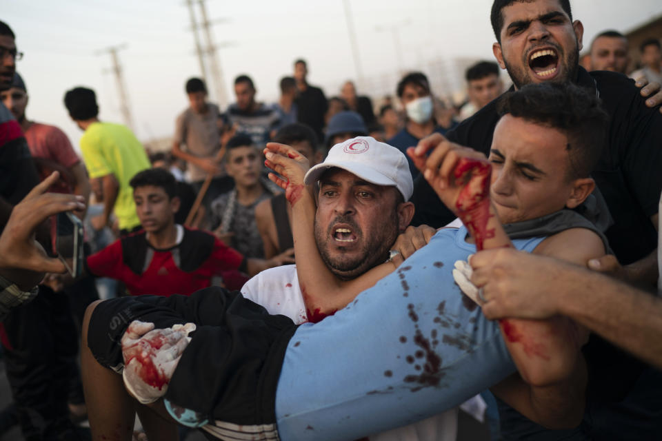 A young Palestinian protester is carried to an ambulance after being shot during a protest at the entrance of Erez border crossing between Gaza and Israel, in the northern Gaza Strip, Tuesday, Sept. 4, 2018. The Health Ministry in Gaza says several Palestinians were wounded by Israeli fire as they protested near the territory's main personnel crossing with Israel. (AP Photo/Felipe Dana)