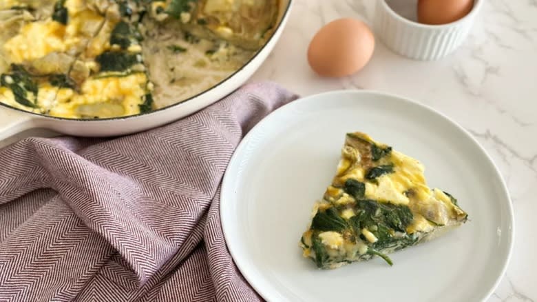 spinach artichoke frittata in bowl, slice on plate