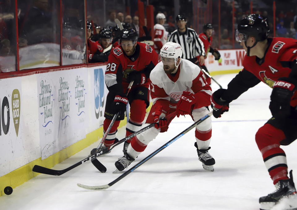 Ottawa Senators left wing Brady Tkachuk (7) moves in as teammate Ottawa Senators right wing Connor Brown (28) and Detroit Red Wings defenseman Filip Hronek (17) vie for control of the puck during second period NHL hockey action in Ottawa, Saturday, Feb. 29, 2020. (Fred Chartrand/The Canadian Press via AP)