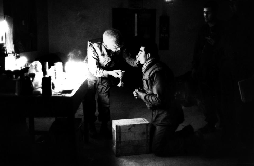 <p>Marine chaplain Eli Tavesian giving communion to marine Louis A Loya, at Forward Command Post in Hue, Vietnam. (Photo: Terry Fincher/Daily Express/Hulton Archive/Getty Images) </p>