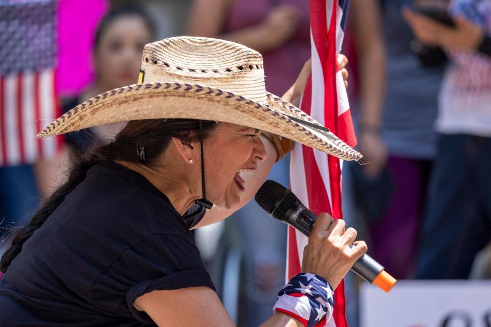 A woman holds an American flag and prays 