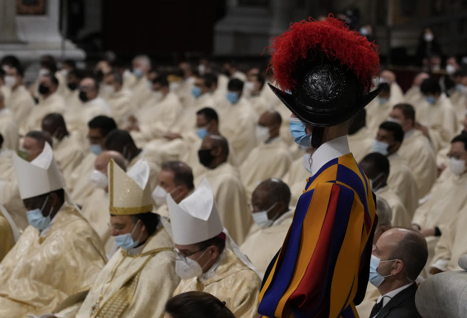 A Swiss Guard stands as Pope Francis celebrates Christmas Eve Mass, at St. Peter's Basilica, at the Vatican, Friday Dec. 24, 2021. Pope Francis is celebrating Christmas Eve Mass before an estimated 1,500 people in St. Peter's Basilica. He's going ahead with the service despite the resurgence in COVID-19 cases that has prompted a new vaccine mandate for Vatican employees. (AP Photo/Alessandra Tarantino)