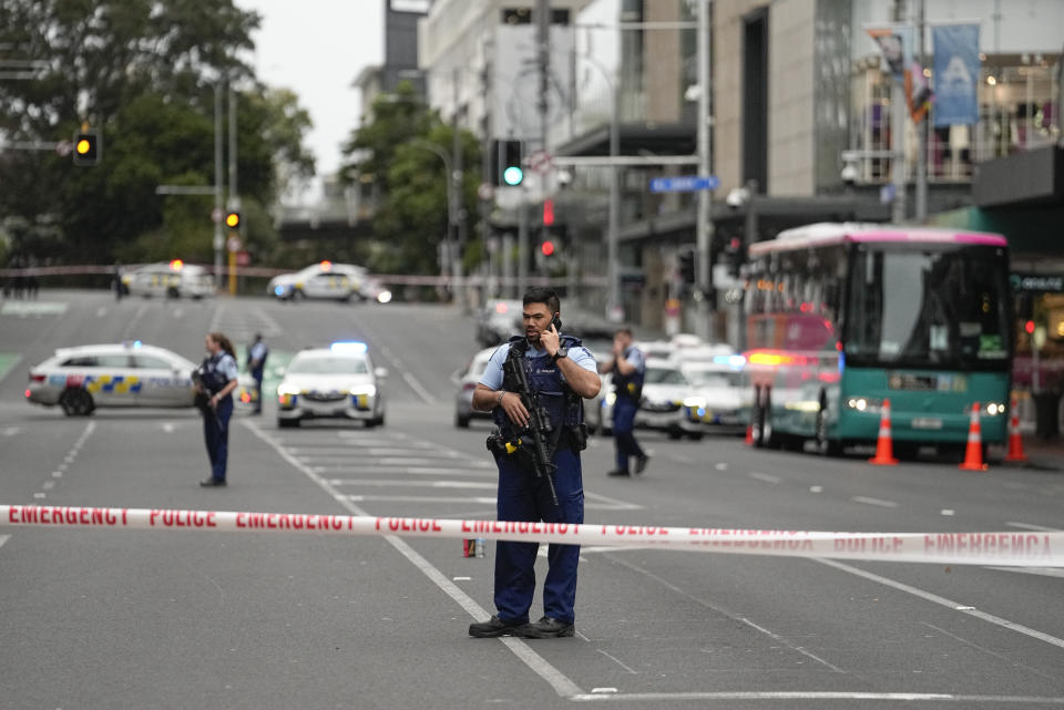 Armed New Zealand police officers stand at a road block in the central business district following a shooting in Auckland, New Zealand, Thursday, July 20, 2023. New Zealand police are responding to reports that a gunman has fired shots in a building in downtown Auckland. (AP Photo/Abbie Parr)