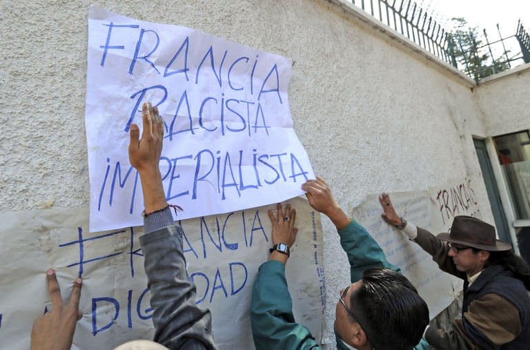 Bolivians hang signs of protest on the exterior wall of the French embassy in La Paz on June 3, 2013