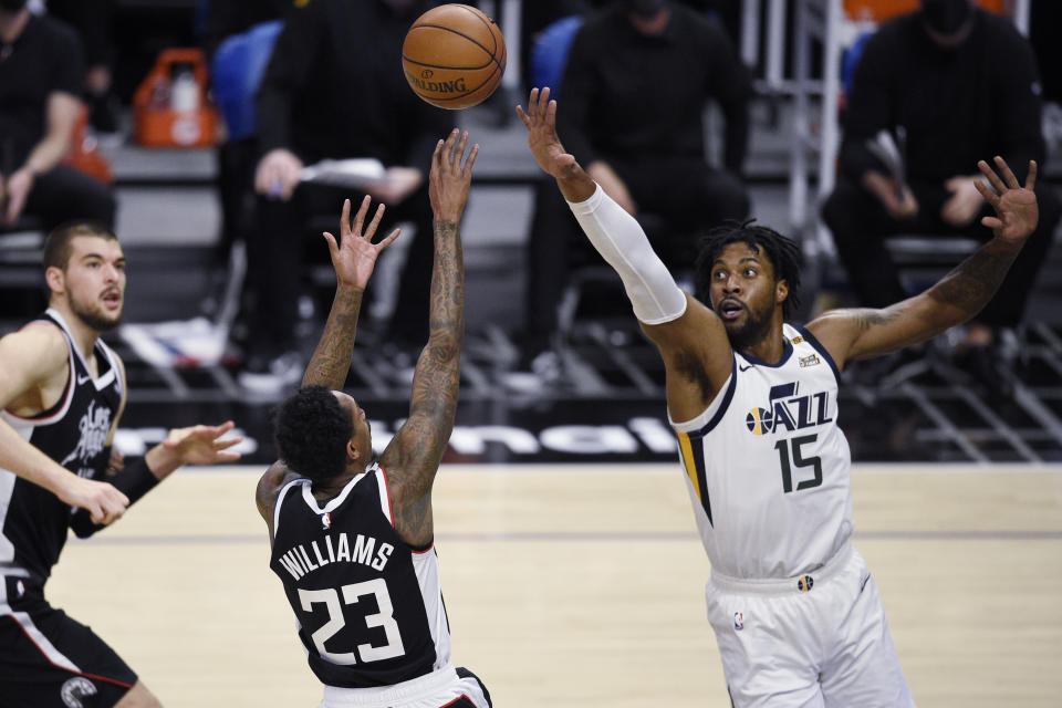 Los Angeles Clippers guard Lou Williams (23) shoots while Utah Jazz center Derrick Favors defends during the first half of an NBA basketball game in Los Angeles, Friday, Feb. 19, 2021. (AP Photo/Kelvin Kuo)