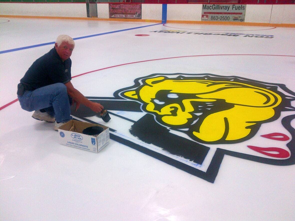 Bud MacInnis paints the bulldog logo at the Antigonish Arena. He says he's grateful for the funding from the province because running a rink is tough financially, even at the best of times. (Submitted by Bud MacInnis - image credit)