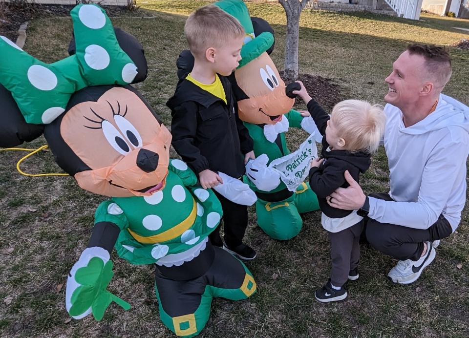 Lance Murphy, shown here with sons Bodie (left) and Banks, grew up in Waukon, where his Irish-loving family always built a float for the town’s big St. Patrick’s Day parade. That culture has carried over to his North Liberty home on Cattail Lane with inflatables.