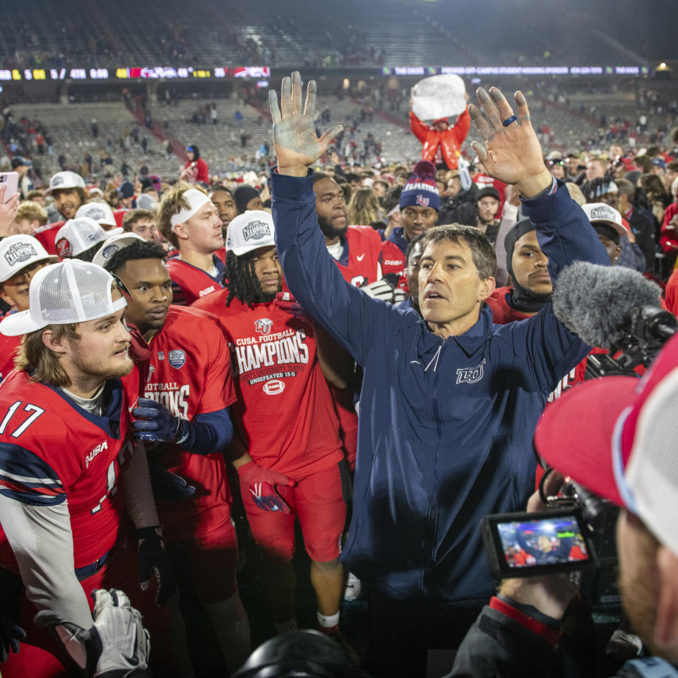 Liberty coach Jamey Chadwell celebrates with players after a win over New Mexico State in the Conference USA championship NCAA college football game Friday, Dec. 1, 2023, in Lynchburg, Va. (AP Photo/Robert Simmons)