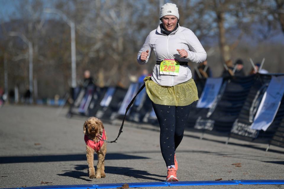 Elizabeth Neunsinger crosses the finish line with her dog.