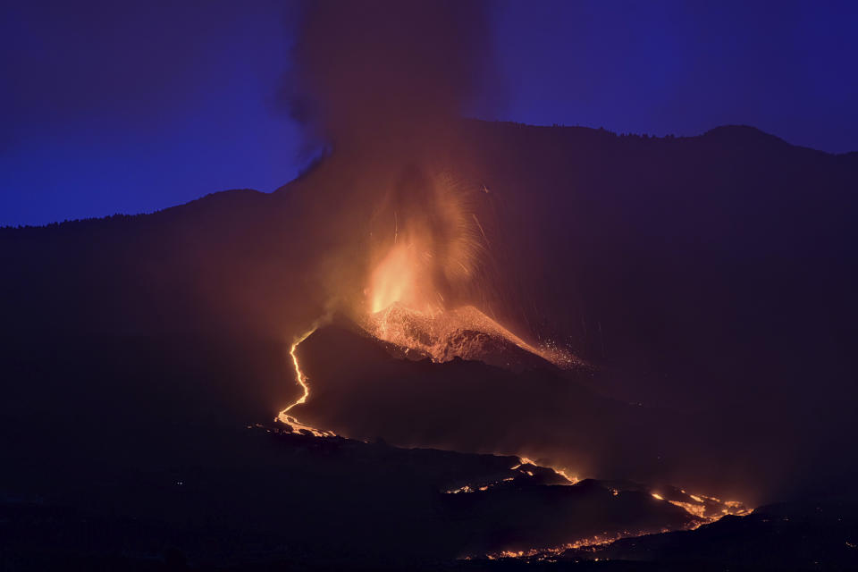 Lava flows from a volcano on the Canary island of La Palma, Spain in the early hours of Sunday Sept. 26, 2021. A volcano in Spain's Canary Islands is keeping nerves on edge several days since it erupted, producing loud explosions, a huge ash cloud and cracking open a new fissure that spewed out more fiery molten rock. (AP Photo/Daniel Roca)