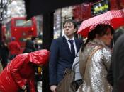 Pedestrians walk in wet and windy weather on Oxford Street in central London December 23, 2013. REUTERS/Olivia Harris