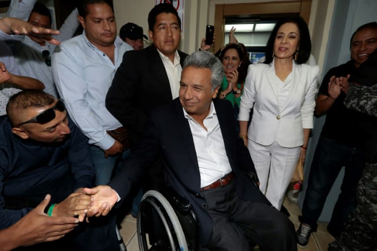 The Ecuadorean presidential candidate of the Alianza PAIS party, Lenin Moreno, accompanied by his wife Rocio Gonzalez (in white), arrives at a polling station in Quito on February 19, 2017 to vote during general election