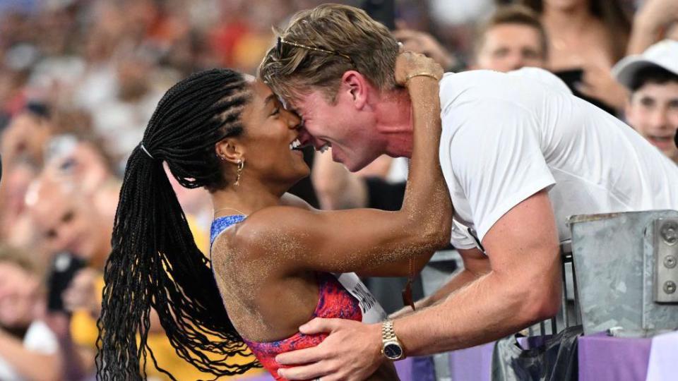 Tara-Davis Woodhall hugging husband Hunter after winning Olympic long jump gold