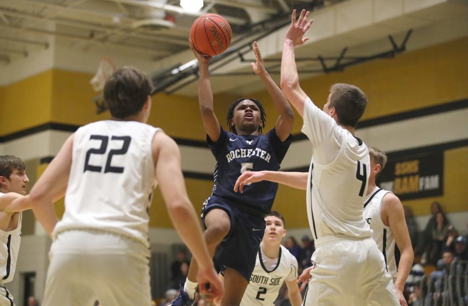 Rochester's Xavier Rigby (5) goes for a layup over the head of South Side's Jacob Strnisa (4) during the second half Friday night at South Side High School.