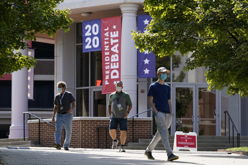 People walk outside the Curb Event Center at Belmont University as preparations take place for the second Presidential debate, Tuesday, Oct. 20, 2020, in Nashville, Tenn. President Donald Trump and Democratic presidential candidate, former Vice President Joe Biden are scheduled to debate Thursday, Oct. 22. (AP Photo/Patrick Semansky)