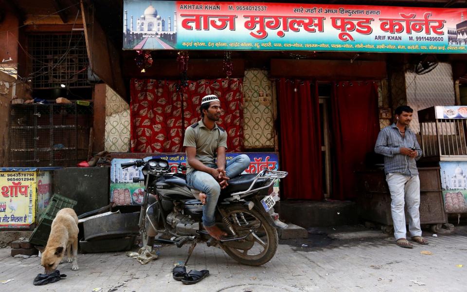 A Muslim man looks on outside a closed restaurant in Gurugram - REUTERS