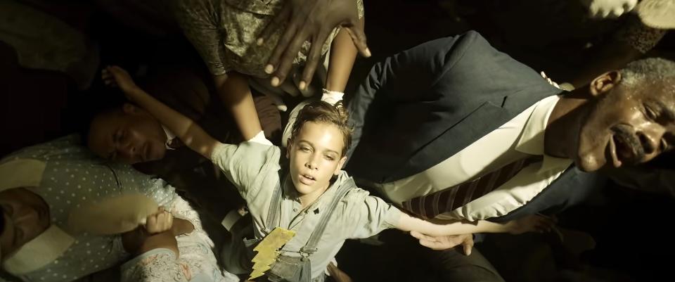 Elvis as a young boy wearing a lightning bolt around his neck in church fainting