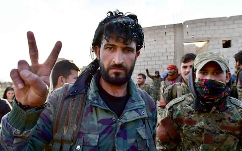 Fighters from the Syrian Democratic Forces (SDF) gesture the "V" for victory sign as they come back from the frontline in the Islamic State group's last remaining position in the village of Baghuz - Credit: AFP