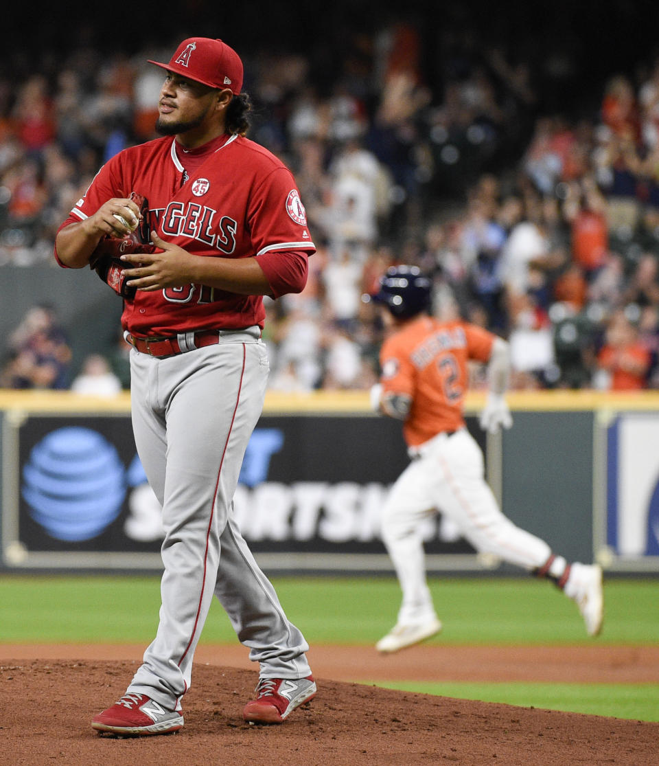 Los Angeles Angels starting pitcher Jaime Barria, left, walks off the mound as Houston Astros' Alex Bregman, back right, rounds the bases after hitting a solo home run during the first inning of a baseball game Friday, Sept. 20, 2019, in Houston. (AP Photo/Eric Christian Smith)