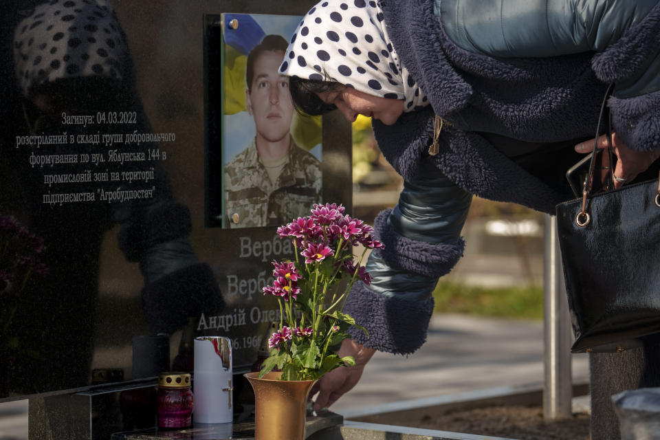 Nataliia Verbova, wife of Andrii Verbovyi, one of eight men killed by Russian forces near a building on Yablunska street, visits her husband's grave in Bucha, Ukraine, Tuesday, March 26, 2024. Days after Russian forces withdrew from the area in late March, in the dramatic first weeks of the full-scale invasion, a photo taken by AP Photographer Vadim Ghirda revealed what happened to the eight men. (AP Photo/Vadim Ghirda)
