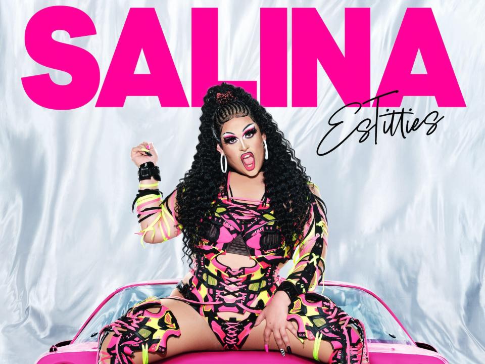 Salina EsTitties poses for her season 15 "RuPaul's Drag Race" headshot in a patterned two-piece, sneaker boots, and hoop earrings.