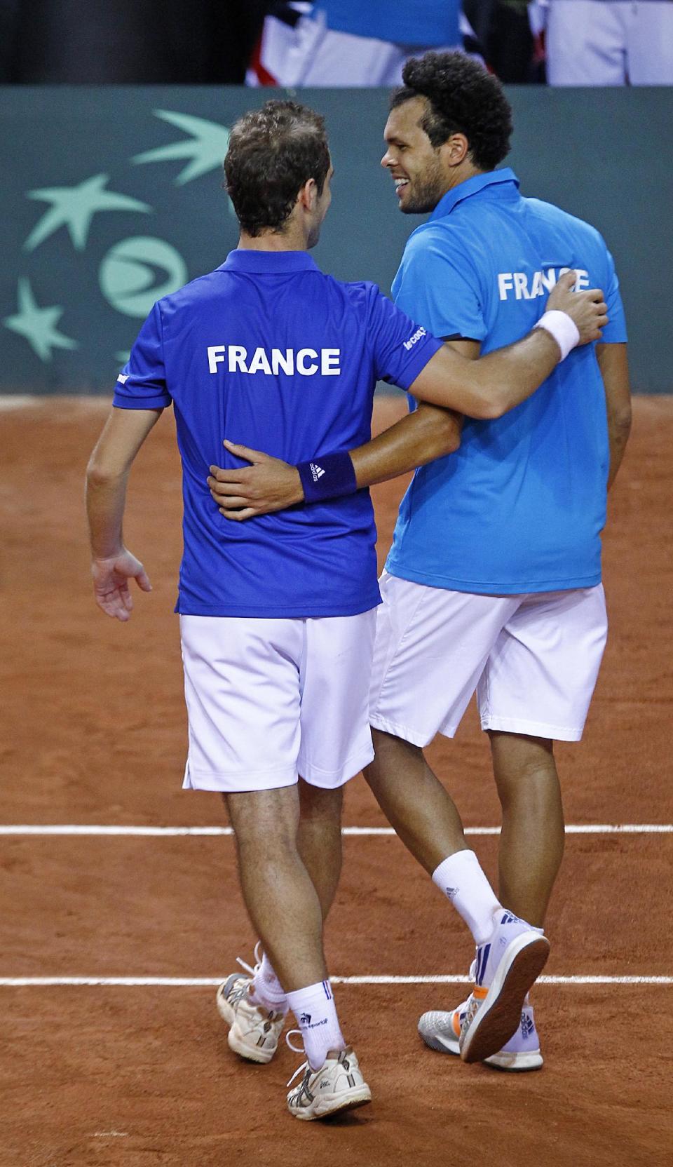 French player Jo-Wilfried Tsonga, right, and teammate Richard Gasquet, after they won their double match against Australian players Lleyton Hewitt and Chris Guccione in the first round of the Davis Cup between France and Australia, in La Roche sur Yon, western France, Saturday Feb. 1, 2014. France qualifies for the next round with a 3-0 score.(AP Photo/Remy de la Mauviniere)