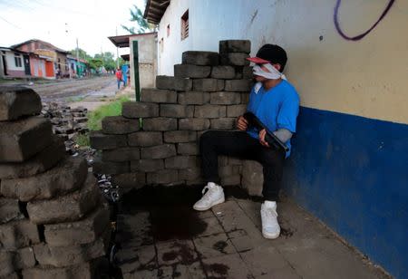 A pro-government supporter sits in a barricade after clashes with demonstrators in the indigenous community of Monimbo in Masaya, Nicaragua July 17, 2018. REUTERS/Oswaldo Rivas