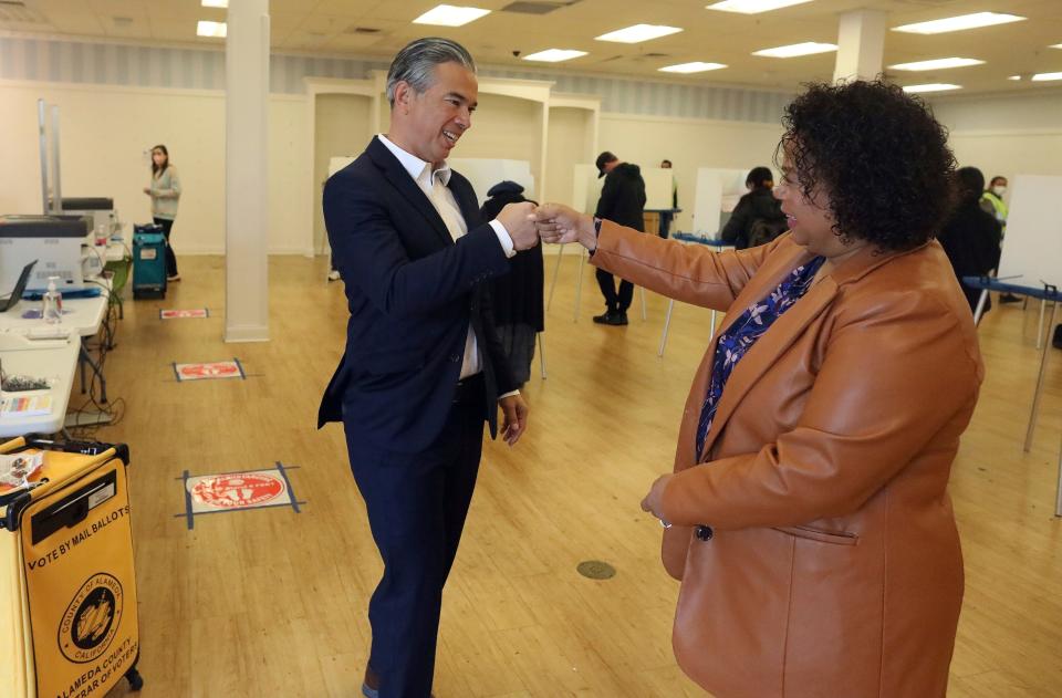 California Attorney General Rob Bonta, left, fist bumps his wife Assemblymember Mia Bonta after the couple dropped off their ballots at a voting center on Tuesday, Nov. 8, 2022, in Alameda, Calif.