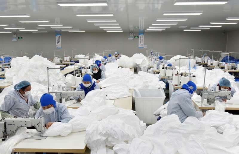 Workers make protective suits at a factory, as the country is hit by an epidemic of the new coronavirus, in Chaohu, Anhui