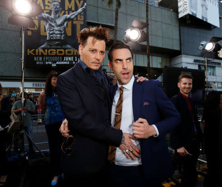 Cast members Johnny Depp (L) and Sacha Baron Cohen pose at the premiere of "Alice Through the Looking Glass" at El Capitan theatre in Hollywood, U.S., May 23, 2016. REUTERS/Mario Anzuoni