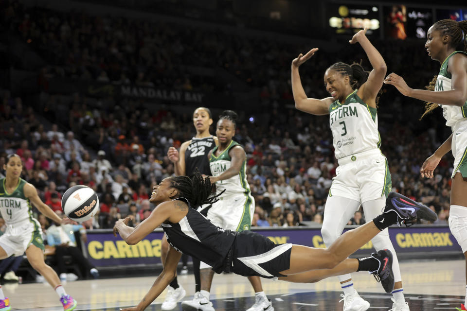 Las Vegas Aces guard Tiffany Hayes falls to the court after being fouled by Seattle Storm forward Nneka Ogwumike (3) during the first half of a WNBA basketball game in Las Vegas on Friday, June 7, 2024. (Steve Marcus/Las Vegas Sun via AP)