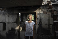 Zhanna Dynaeva stands inside her house which was destroyed by Russian bombardment, in the village of Novoselivka, near Chernihiv, Ukraine, on Saturday, Aug. 13, 2022. Residents in many heavily-damaged areas in Ukraine have set up their own initiatives to rebuild homes before the winter as international organizations rush aid to Ukraine to help with the reconstruction effort. (AP Photo/Evgeniy Maloletka)